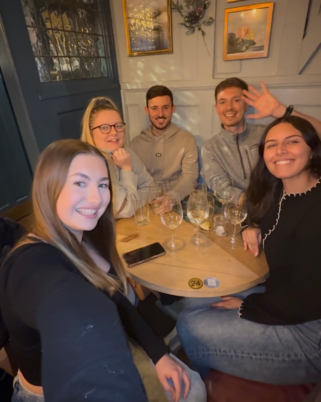 A group of people smiling together around an Empty Chairs table in Benfleet